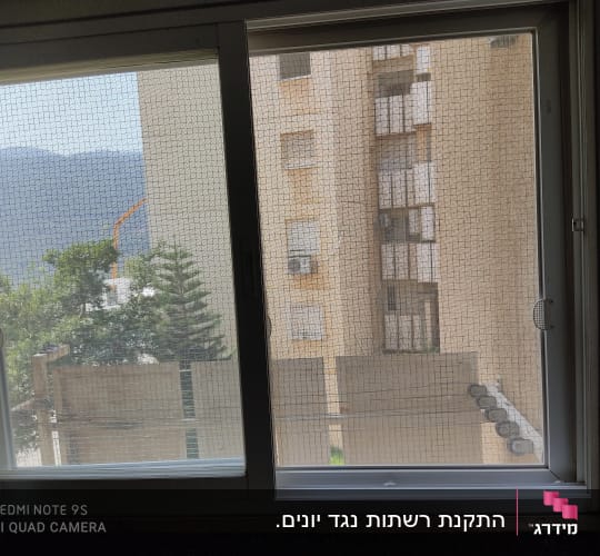חלון הזזה מאלומיניום עם רשת מותקנת בדירה